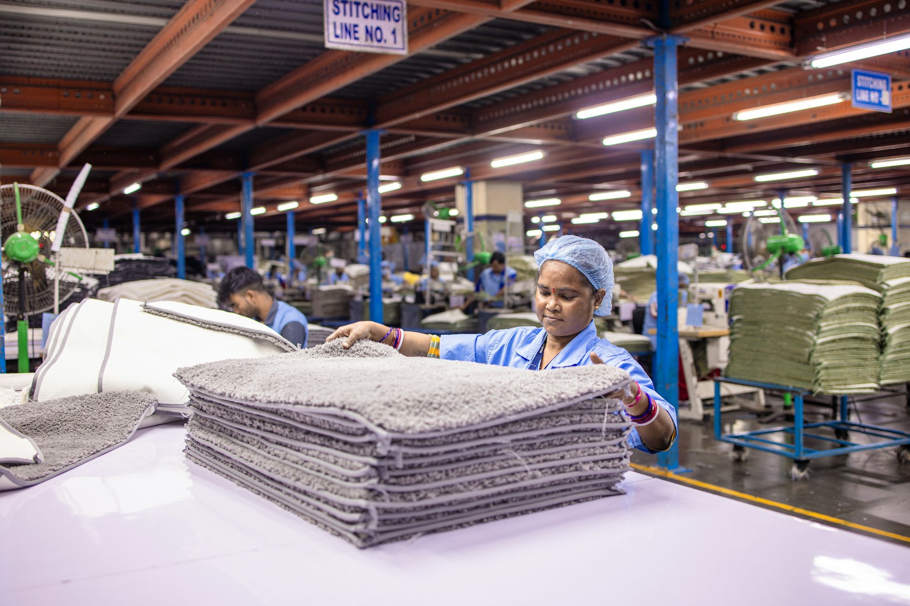 A production worker checking packed materials on a factory floor